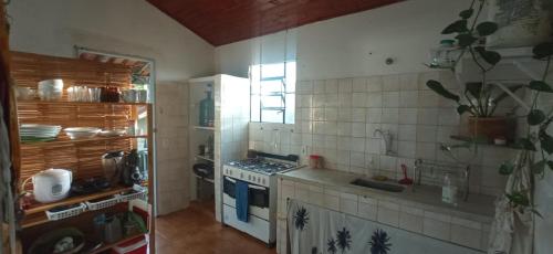 a small kitchen with a stove and a window at Casa Astral Buzios in Búzios