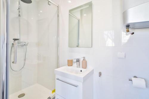 La salle de bains blanche est pourvue d'un lavabo et d'une douche. dans l'établissement Amazing Appartment 4 Peoples, à Montrouge