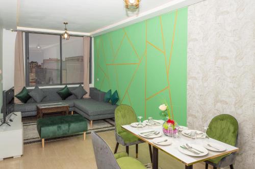 a dining room with a table and a couch at Palm D'or-Appartement familial de luxe au centre de Dakhla in Dakhla