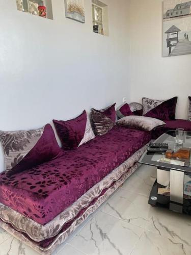 un sofá púrpura en una habitación con mesa en Appartement- Terrasse sublime en El Jadida