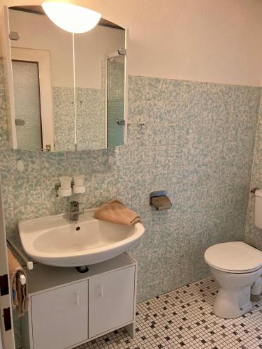 a bathroom with a sink and a toilet and a mirror at Nordsee 411 in Wangerooge