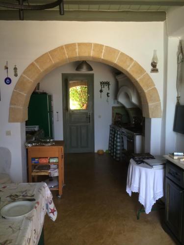 an archway in a kitchen with a table and a door at Fishermen Beach House in Dhiakofti