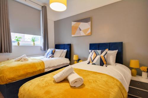 two beds in a room with yellow and blue at Home Perfect for Contractors - Free Parking and Free WI-FI in Wallasey