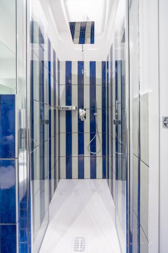 a bathroom with a shower with blue and white tiles at 4blu Camere Marine in Maiori