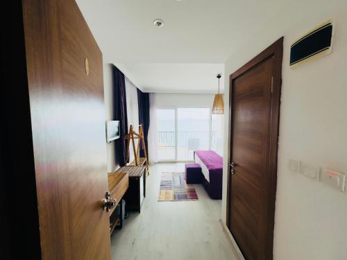 a hallway with a door and a room with a bed at Fuda Hotel in Datca