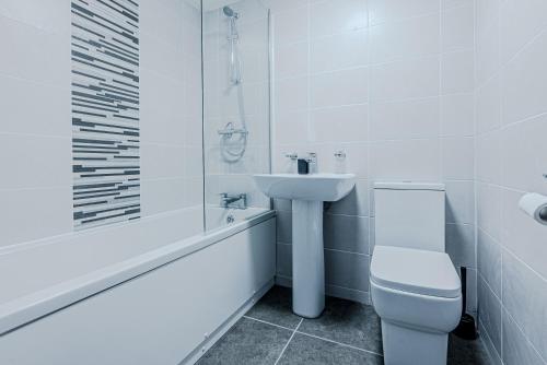 La salle de bains blanche est pourvue de toilettes et d'un lavabo. dans l'établissement Stunning Three Bedroom Townhouse In The Jewellery Quarter, Birmingham City Centre Sleeps 5- Free Parking, à Birmingham