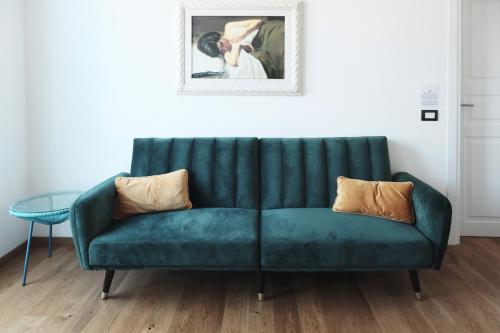 a green couch in a living room with a picture at ComeCasa Città Studi Terraced Apartment in Milan