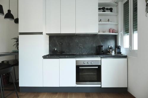 a kitchen with white cabinets and an oven at ComeCasa Città Studi Terraced Apartment in Milan