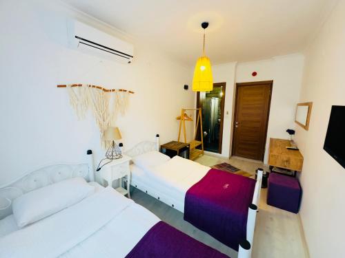 a bedroom with two beds and a pendant light at Fuda Hotel in Datca