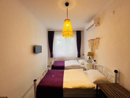 two beds in a small room with a window at Fuda Hotel in Datca