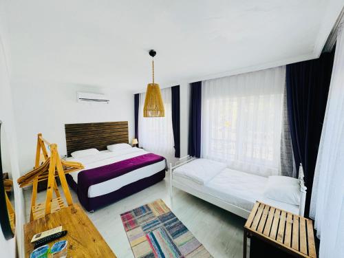 a bedroom with two beds and a bench in it at Fuda Hotel in Datca