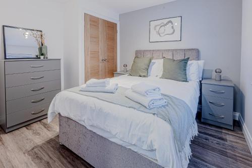 a bedroom with a bed with towels on it at Modern 3-Bedroom Townhouse - Free Secure Parking - Jewellery Quarter in Birmingham