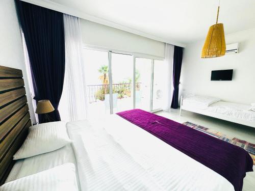 a bedroom with two beds and a large window at Fuda Hotel in Datca