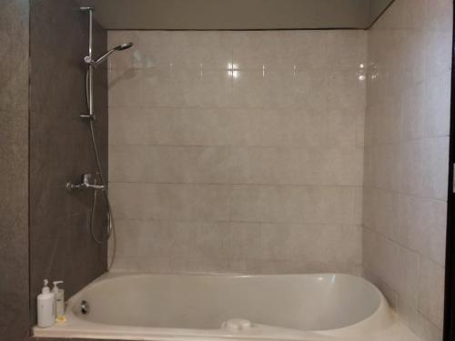 a bath tub in a bathroom with a shower at Sunshine Bungalows in Amed