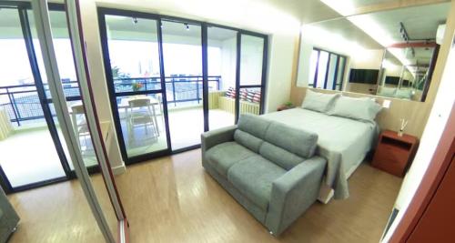 a bedroom with a bed and a couch and a balcony at VN Bom Retiro in Sao Paulo