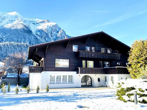 ein Haus im Schnee mit Bergen im Hintergrund in der Unterkunft Modern designed, luxury mountain view Apartment in Kandersteg