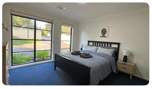 a bedroom with a bed and a large window at Balgowlah as home in Sydney