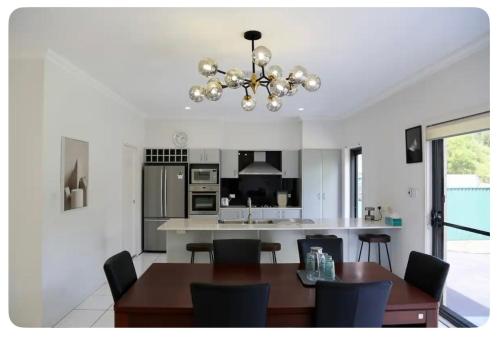 a kitchen and dining room with a table and a chandelier at Balgowlah as home in Sydney
