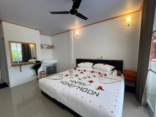 a bedroom with a large bed with red flowers on it at Dacha Thoddoo White Sand in Thoddoo