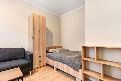 a bedroom with a bed and a couch at Tiny and cosy studio only 4 you in Katowice