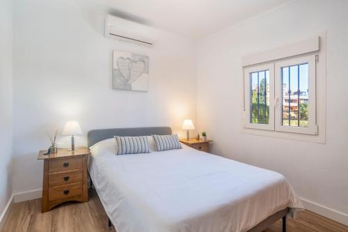 1 dormitorio blanco con 1 cama y 2 ventanas en Beautiful 5 Bedroom Villa, Sea Views, Private Pool, Estepona newly refurbished, en Estepona