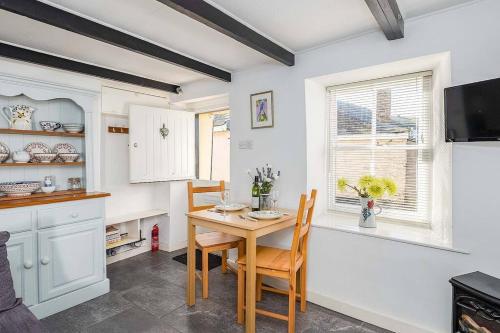 Una cocina con mesa y sillas y una ventana. en Homestead, en Port Isaac