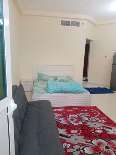 ein Schlafzimmer mit einem Bett, einem Sofa und einem Teppich in der Unterkunft ORIENT TOWER AJMAN in Ajman 