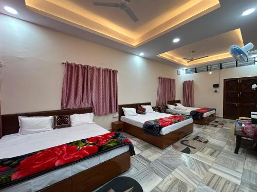 Un dormitorio con dos camas y una sala de estar. en Aashirwad Residency, en Ujjain