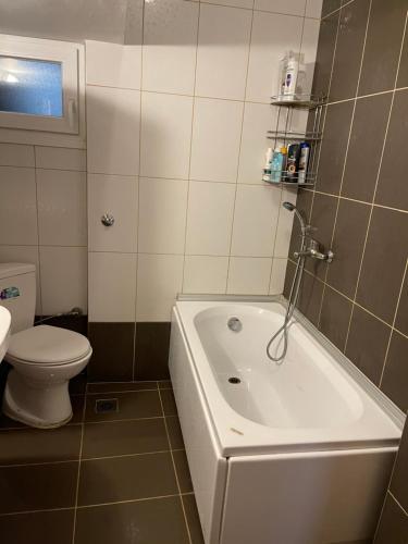 bagno con vasca bianca e servizi igienici di Stone Apartment a Salonicco