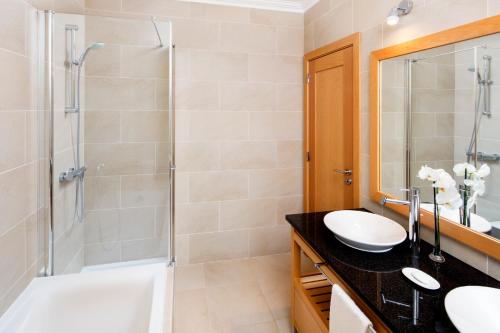 a bathroom with a shower and a sink and a tub at The Beachfront - Praia D'El Rey Golf & Beach Resort in Casal da Lagoa Seca