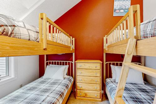 two bunk beds in a room with an orange wall at Forest Hideaway in Waterville Valley