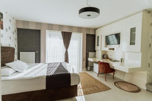 a bedroom with a bed and a desk and a window at Blackmoon Villa Edirne in Edirne