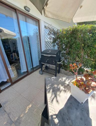 a patio with a table and plants and a grill at La Marina home in Concón