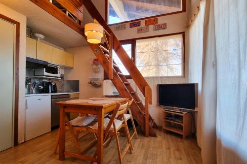 ヴァルベールにあるApartment for 6 people in the heart of Valberg resortの小さな家の中にテーブルと階段付きのキッチンがあります。