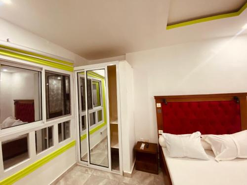 a bedroom with a bed with a red headboard at Charme Urbain de Douala in Douala