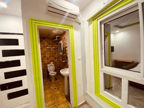 a bathroom with a window and a toilet at Charme Urbain de Douala in Douala