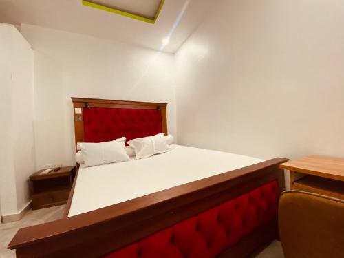 a bedroom with a large bed with a red headboard at Charme Urbain de Douala in Douala