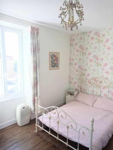 une chambre avec un lit, une fenêtre et un lustre dans l'établissement Montemboeuf centre Town House free wifi, à Montembœuf