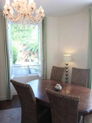 une table à manger avec des chaises et un lustre dans l'établissement Montemboeuf centre Town House free wifi, à Montembœuf
