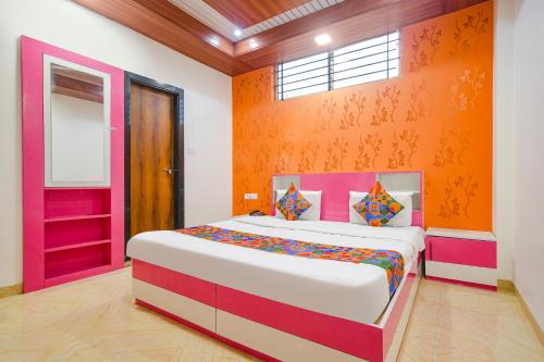 um quarto com uma cama grande e uma parede laranja em FabExpress Dream paradise em Indore