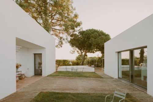 a white house with a courtyard with chairs at Casa Modesta in Olhão