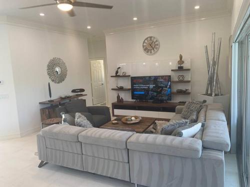 a living room with a large couch and a table at AAA - Marco Island Luxury Home, Walk To The Beach. in Marco Island