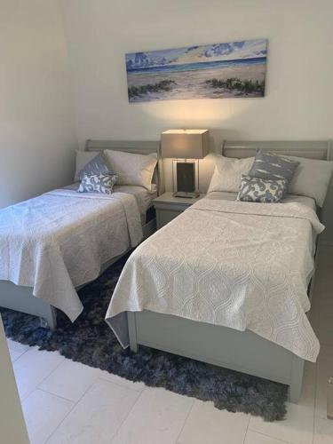 a bedroom with two beds and a table with a lamp at AAA - Marco Island Luxury Home, Walk To The Beach. in Marco Island