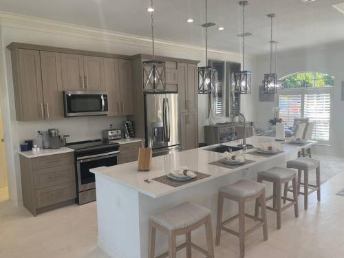 a kitchen with a large island with bar stools at AAA - Marco Island Luxury Home, Walk To The Beach. in Marco Island