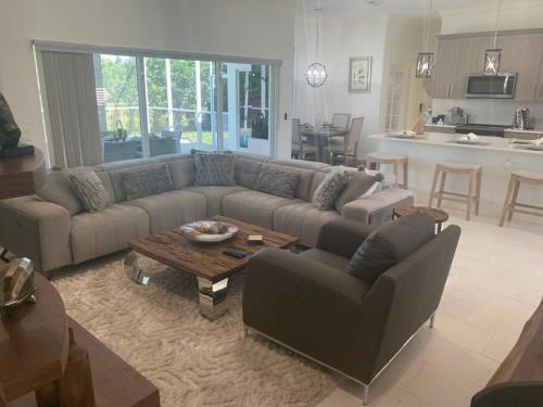 a living room with a couch and a table at AAA - Marco Island Luxury Home, Walk To The Beach. in Marco Island