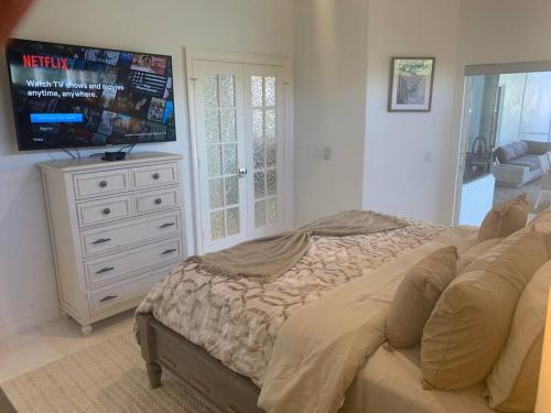 a bedroom with a bed and a flat screen tv at AAA - Marco Island Luxury Home, Walk To The Beach. in Marco Island