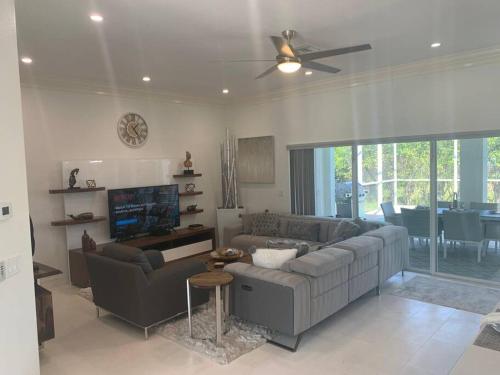a living room with a couch and a ceiling fan at AAA - Marco Island Luxury Home, Walk To The Beach. in Marco Island
