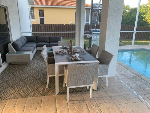 a patio with a table and chairs next to a pool at AAA - Marco Island Luxury Home, Walk To The Beach. in Marco Island