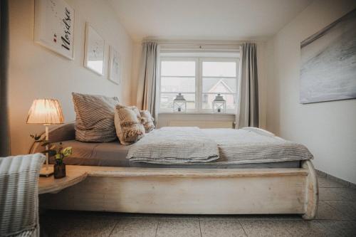 a bed in a room with a window at Friesenhus Dangast in Dangast