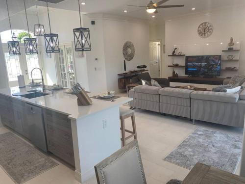 a kitchen and living room with a couch and a table at AAA - Marco Island Luxury Home, Walk To The Beach. in Marco Island